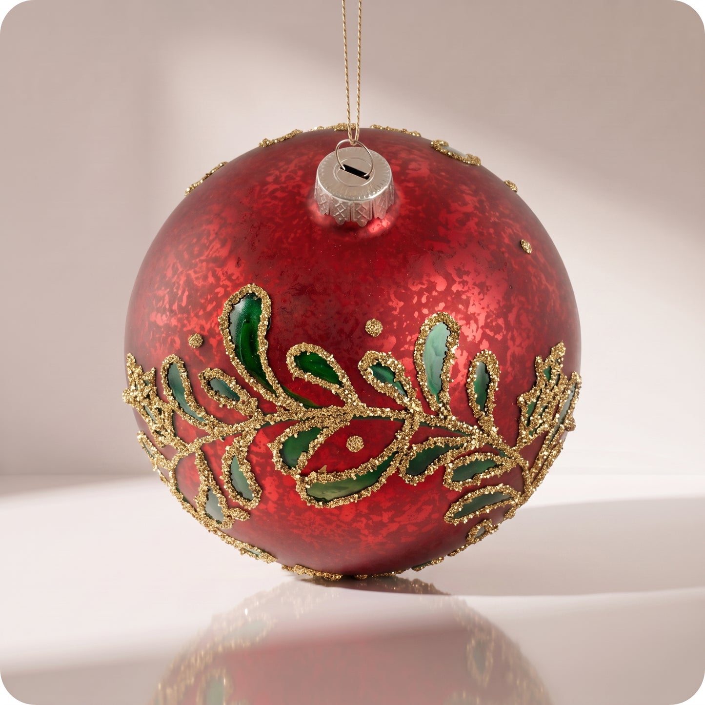 Esfera de cristal rojo con hojas verdes y brillos dorados 12 cm