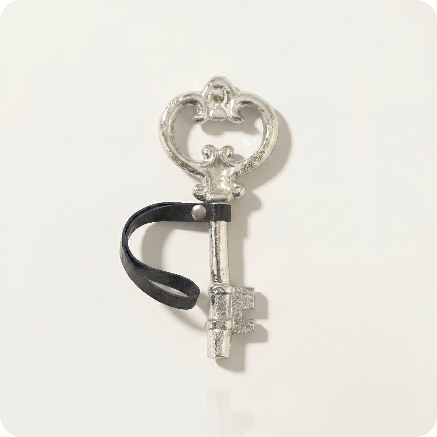 Adorno de llave antigua con correa de cuero plateada