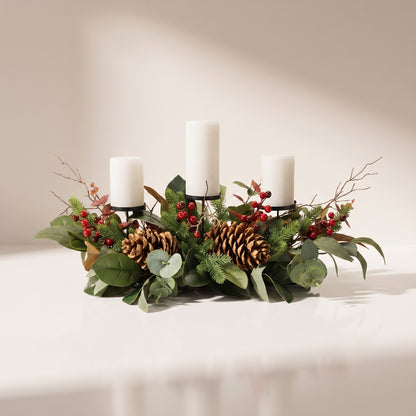 Centro de mesa con piñas, hojas de magnolia y porta velas