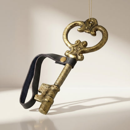 Adorno de llave antigua con correa de cuero dorada