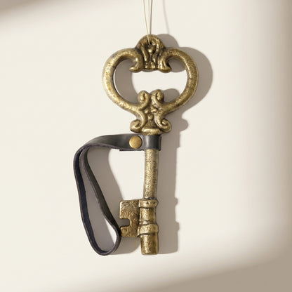 Adorno de llave antigua con correa de cuero dorada