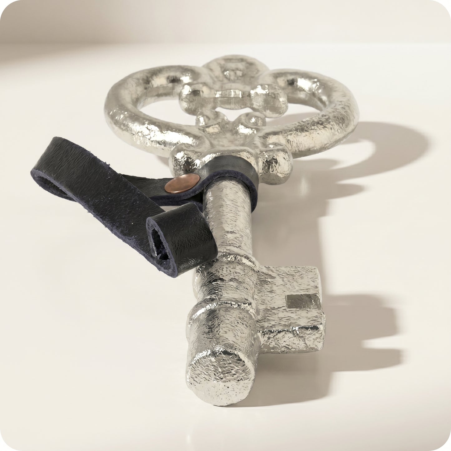 Adorno de llave antigua con correa de cuero plateada
