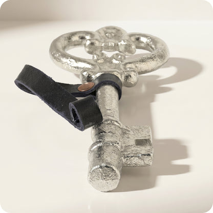 Adorno de llave antigua con correa de cuero plateada